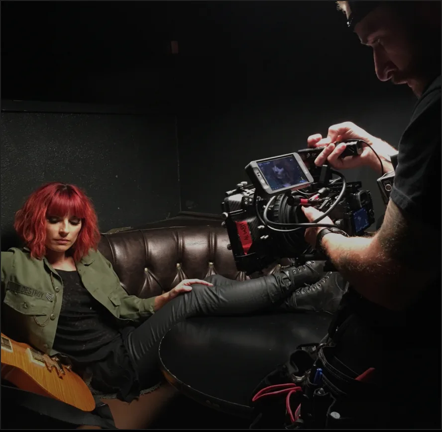 Camera operator filming a musician